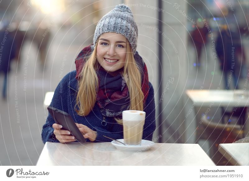 Junge blonde Frau mit mobilem trinkendem Kaffee Latte Macchiato Lifestyle Glück schön Gesicht lesen Winter Tisch Technik & Technologie Erwachsene 1 Mensch