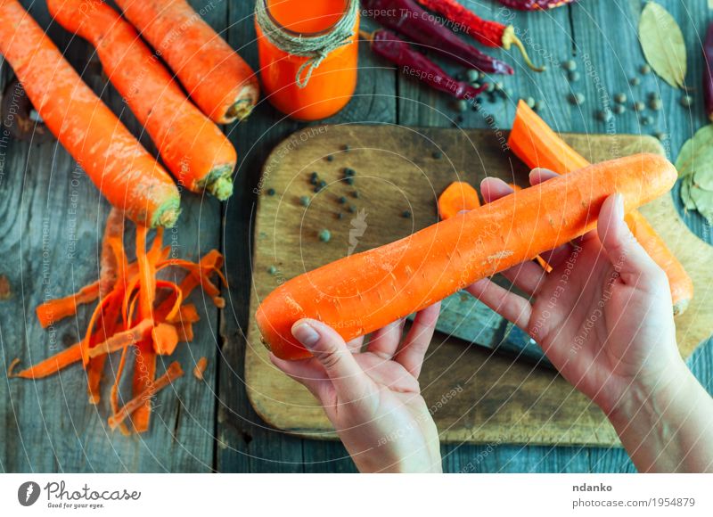 Große frische Karotten in einer weiblichen Hand Gemüse Kräuter & Gewürze Ernährung Essen Vegetarische Ernährung Diät Getränk Saft Flasche Tisch Frau Erwachsene
