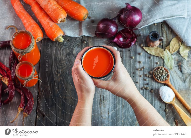Eisen-Becher mit Karottensaft in weiblichen Händen Lebensmittel Gemüse Kräuter & Gewürze Ernährung Getränk Erfrischungsgetränk Saft Tasse Löffel Tisch Frau