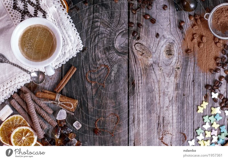 Grauer hölzerner Hintergrund mit schwarzem Kaffee Lebensmittel Frucht Dessert Süßwaren Frühstück Kaffeetrinken Getränk Heißgetränk Kakao Espresso Becher Löffel