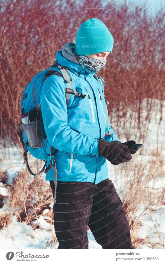 Junge, der den Handy während der Winterreise verwendet Lifestyle Freude Ferien & Urlaub & Reisen Ausflug Abenteuer Freiheit Expedition Schnee Winterurlaub