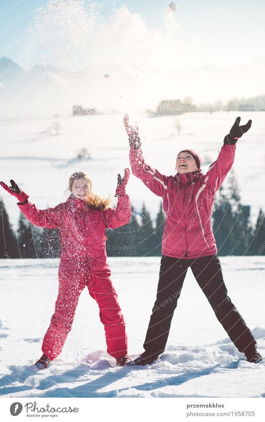 Mutter, die draußen den Schnee mit ihrer Tochter genießt Lifestyle Freude Glück Winter Winterurlaub Mensch Mädchen Frau Erwachsene Eltern