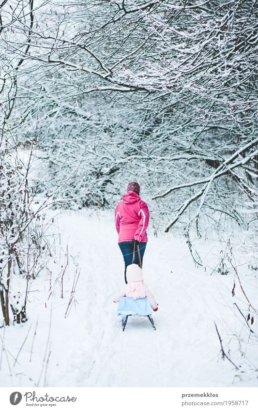 Frau, die Schlitten mit ihrer kleinen Tochter zieht Lifestyle Freude Ausflug Winter Schnee Winterurlaub Kind Mensch Baby Mädchen Erwachsene Eltern Mutter
