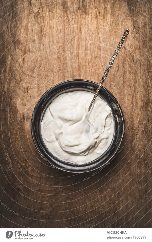 Joghurt oder Sauerrahm in rustikaler Schale mit Löffel Lebensmittel Milcherzeugnisse Ernährung Frühstück Bioprodukte Vegetarische Ernährung Diät