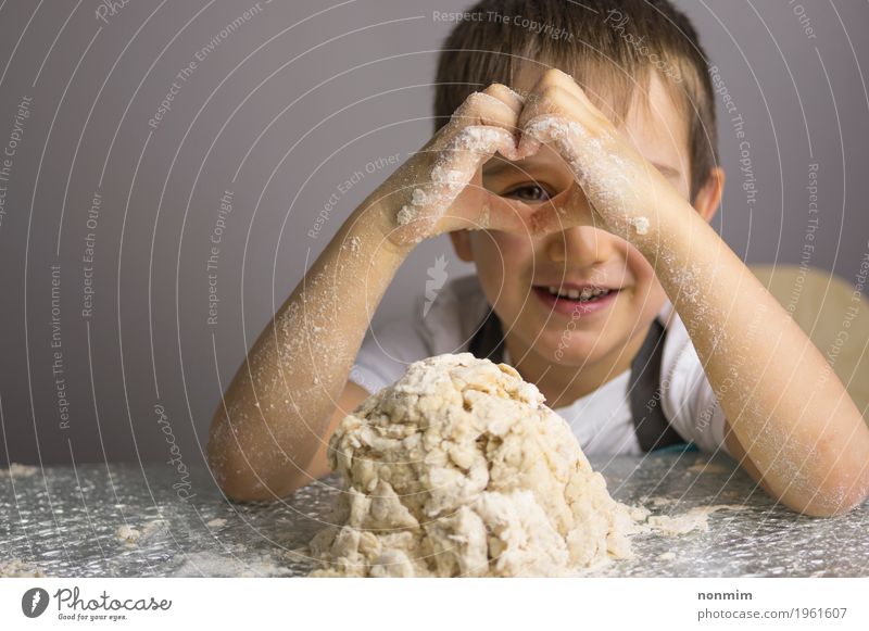 Junge knetet den rohen Teig, der durch Herzformhände schaut Teigwaren Backwaren Brot Freude Spielen Küche Kind Kindheit Hand Lächeln machen unschuldig reizvoll