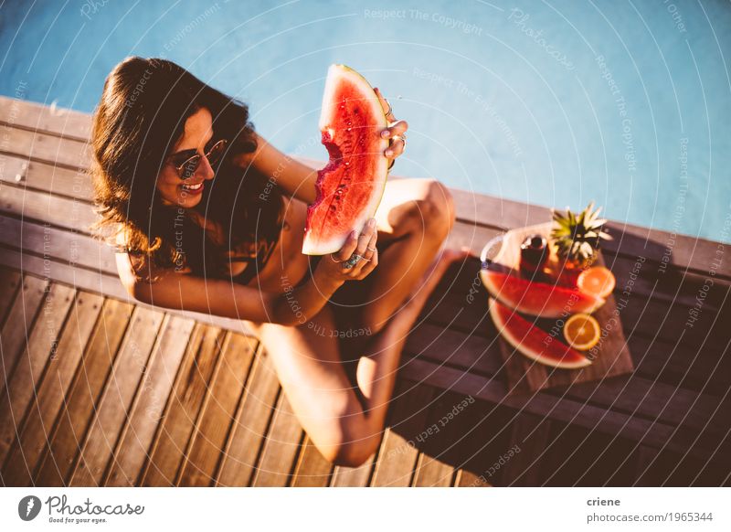 Junge schöne Frauen im Bikini, der am Swimmingpool sitzt Frucht Orange Essen Lifestyle Freude Schwimmbad Schwimmen & Baden Sommer Sommerurlaub Sonnenbad feminin