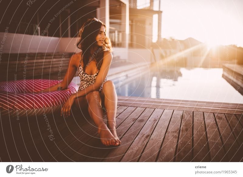 Junge kaukasische Frauen, die am Swimmingpool im Sonnenuntergang sich entspannen Lifestyle Freude Wellness Erholung Spa Schwimmbad Schwimmen & Baden