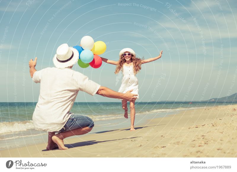 Vater und Tochter mit Ballons spielen am Strand in der Tageszeit. Konzept der freundlichen Familie. Lifestyle Freude Leben Erholung Freizeit & Hobby Spielen