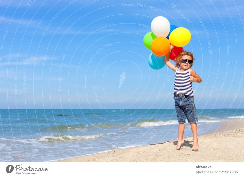 Kleiner Junge mit den Ballonen, die auf dem Strand stehen Lifestyle Freude Glück Erholung Freizeit & Hobby Spielen Ferien & Urlaub & Reisen Ausflug Abenteuer