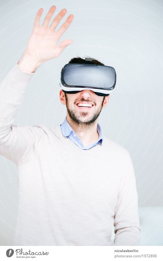 Mann mit VR-Brille winkt Spielen Cyberspace virtual reality simulator Computerspiel Expedition Erfolg Büro Medienbranche Business Sitzung Headset Freude