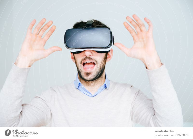 Mann mit VR-Brille erschreckt und hebt die Hände auf weißem Hintergrund virtuell virtuelle realität virtual reality simulator Freude erstaunt Spielen