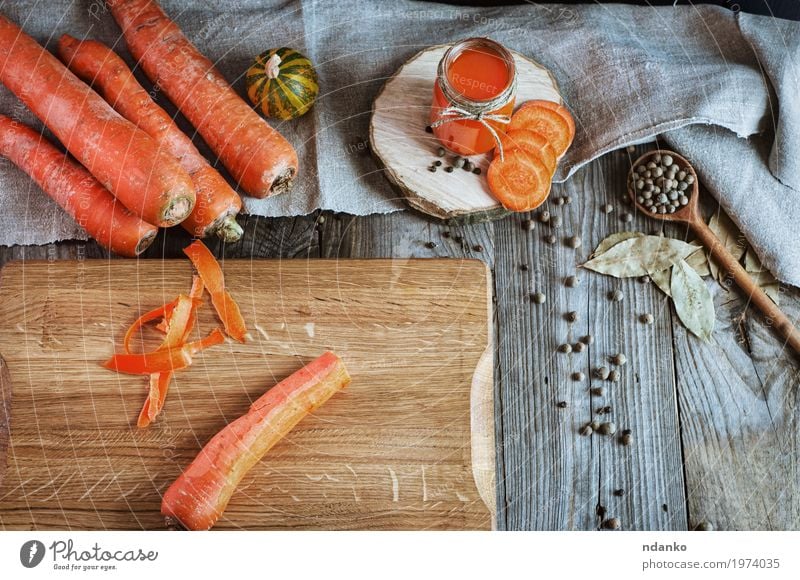 Frische Karotten auf dem Schneidebrett Gemüse Kräuter & Gewürze Ernährung Vegetarische Ernährung Diät Getränk Saft Flasche Glas Löffel Tisch Holz alt frisch