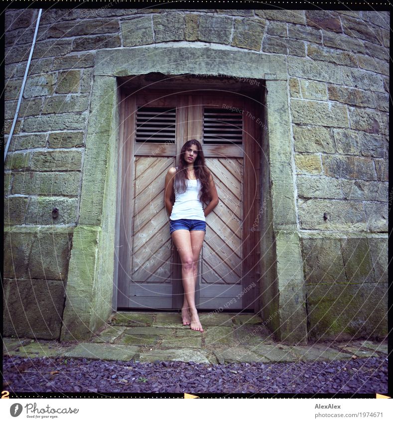 Junge, schlanke, sportliche Frau in Hotpants steht barfuß vor einer Holztür von einem Wasserturm Lifestyle schön Turm Tor Junge Frau Jugendliche Körper Beine