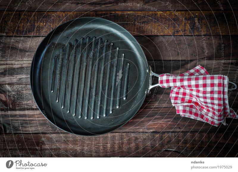 leere Pfanne Grill auf einer Holzoberfläche Geschirr Design Tisch Küche Koch Stoff Metall oben Sauberkeit braun schwarz Tischwäsche Aussicht bügeln braten