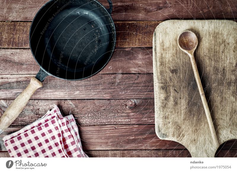 leere schwarze Metallwanne und Schneidebrett auf einer Holzoberfläche Pfanne Löffel Design Tisch Küche Werkzeug Stoff oben Sauberkeit braun Geschirr Tischwäsche