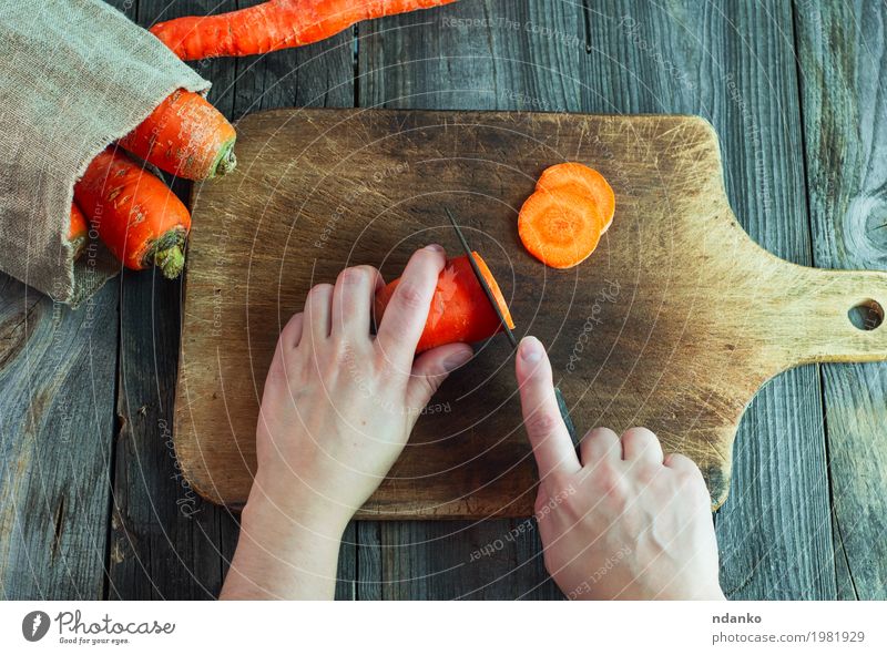 Prozess des Schneidens von Karotten auf Scheiben auf einem Küchenbrett Lebensmittel Gemüse Ernährung Essen Vegetarische Ernährung Diät Messer Tisch Frau