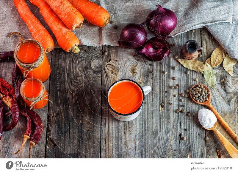 Karottensaft in den Glasgläsern und im Eisen überfallen Lebensmittel Gemüse Kräuter & Gewürze Vegetarische Ernährung Diät Getränk trinken Heißgetränk Saft Tasse