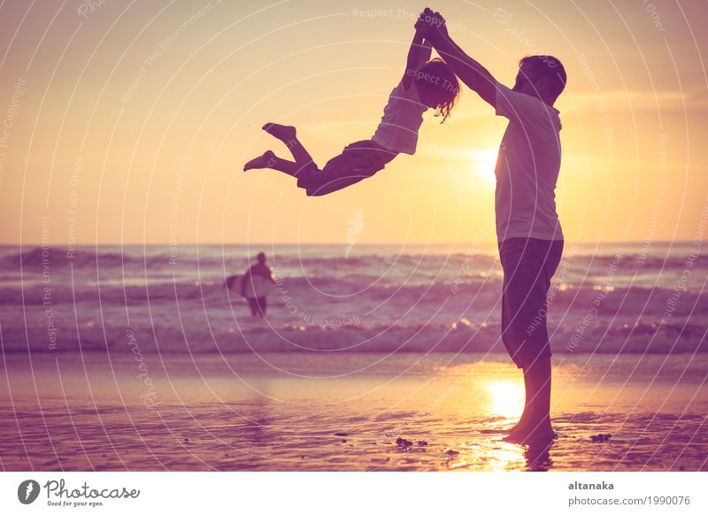 Vater und Sohn, die auf dem Strand zur Sonnenuntergangzeit spielen. Lifestyle Freude Freizeit & Hobby Spielen Ferien & Urlaub & Reisen Ausflug Freiheit Sommer
