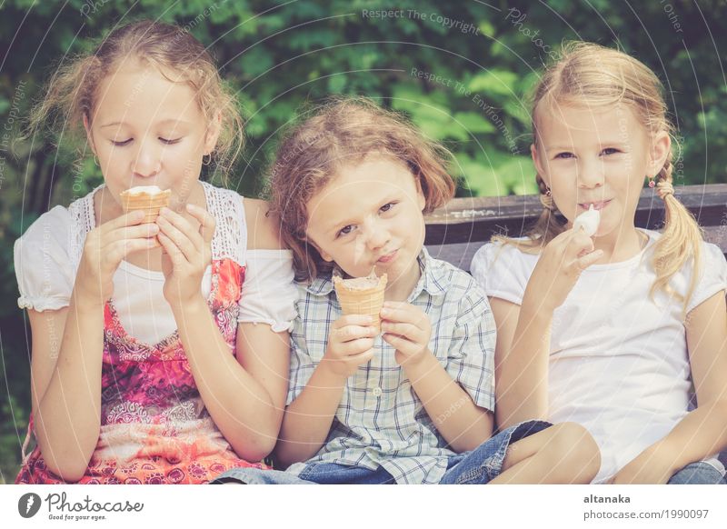 Drei glückliche Kinder, die im Park zur Tageszeit spielen. Dessert Essen Freude Glück schön Gesicht Freizeit & Hobby Ferien & Urlaub & Reisen Sommer Mensch