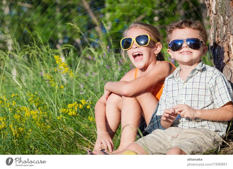 Zwei glückliche Kinder, die nahe dem Baum zur Tageszeit spielen. Lifestyle Freude Glück schön Gesicht Freizeit & Hobby Spielen Ferien & Urlaub & Reisen Freiheit
