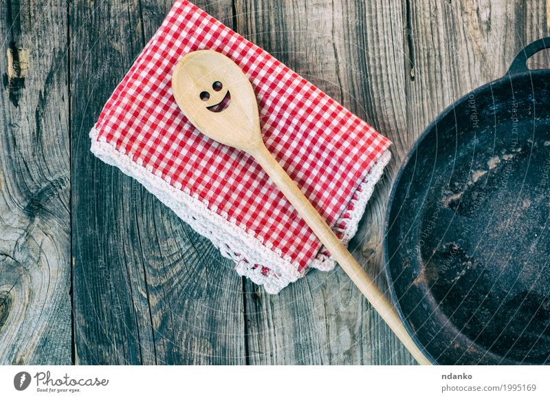 Schwarze Gusseisenbratpfanne mit einem hölzernen Spachtel Geschirr Pfanne Löffel Tisch Küche Restaurant Werkzeug Stoff Kochlöffel Holz Metall oben Sauberkeit