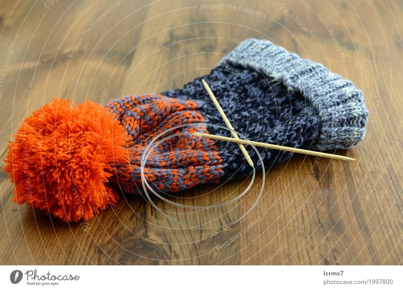 knitting woolly hat. finished hat on table. with needles Freizeit & Hobby Wärme Mode Mütze Wolle stricken Kreativität yarn handmade The Needles Hintergrundbild