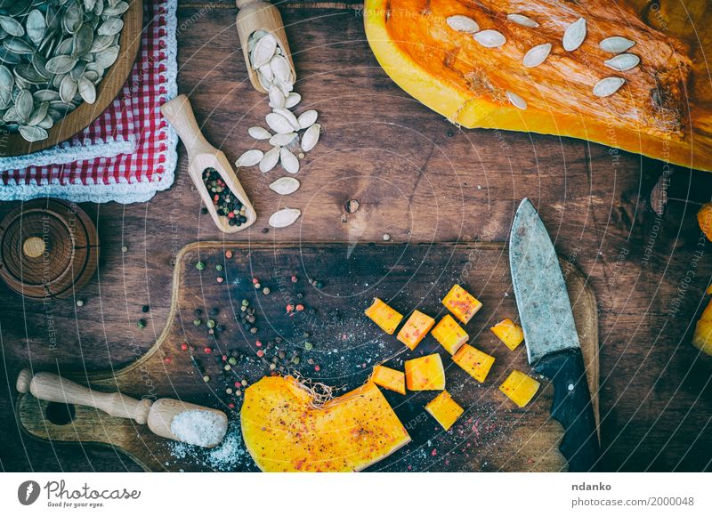 Stücke von Kürbis in Salz und Pfeffer Lebensmittel Gemüse Kräuter & Gewürze Ernährung Essen Vegetarische Ernährung Löffel Holz frisch oben braun orange
