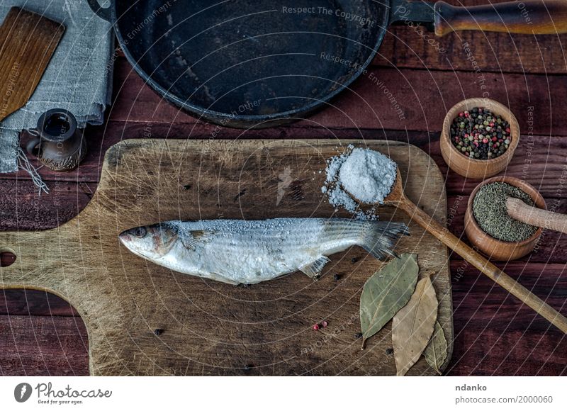 Gefrorener Fisch roch auf einem Küchenbrett Lebensmittel Kräuter & Gewürze Ernährung Essen Diät Pfanne Löffel Tisch Holz Metall frisch oben braun schwarz
