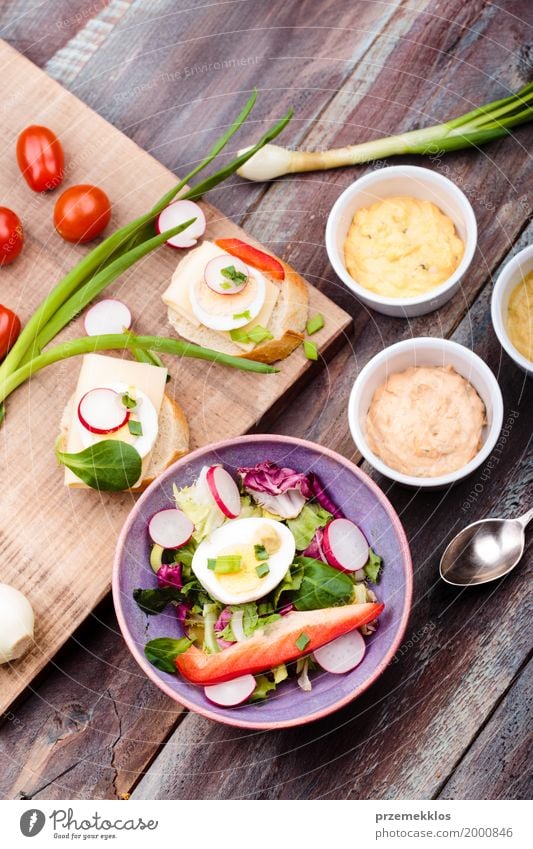 Gesunde Mahlzeit mit Eiern und Gemüse Lebensmittel Salat Salatbeilage Brot Mittagessen Vegetarische Ernährung Diät Schalen & Schüsseln Tisch Holz frisch lecker