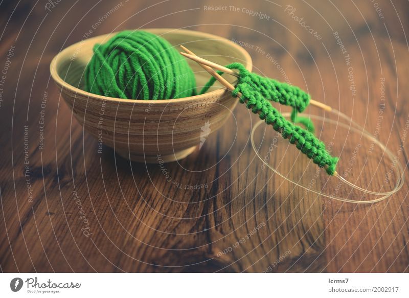 knitting with green wool in a bowl on wooden table. Design Freizeit & Hobby Winter Wärme Mode Wolle stricken Kreativität yarn craft Hintergrundbild handmade