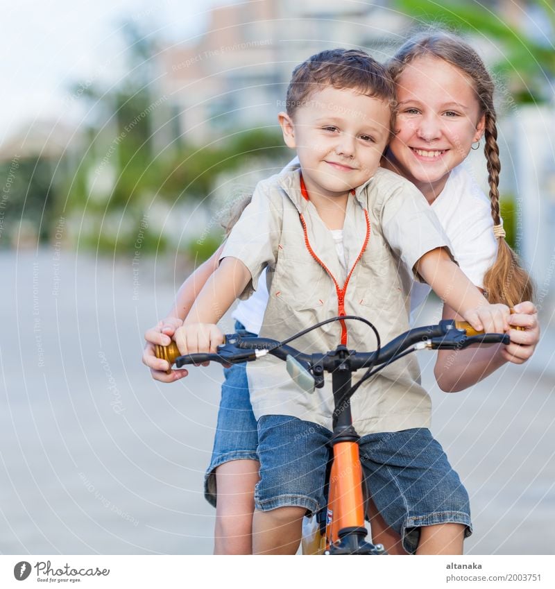 Glückliche Kinder mit dem Fahrrad, das auf der Straße zur Tageszeit steht. Lifestyle Freude Freizeit & Hobby Spielen Sommer Schule Mensch Mädchen Junge
