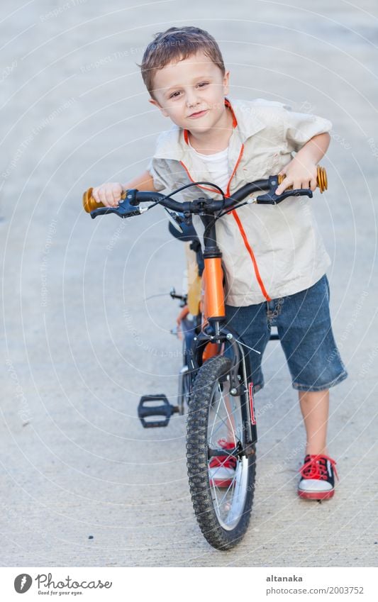 Glücklicher kleiner Junge mit dem Fahrrad, das auf Straße steht Lifestyle Freude Erholung Freizeit & Hobby Abenteuer Sommer Sport Fahrradfahren Kind Mensch Mann