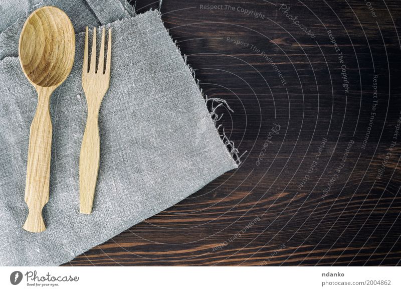 Hölzerner Löffel und Gabel auf grauer Serviette Geschirr Tisch Küche Kochlöffel Holz alt retro braun Speise Utensil Essgeschirr Oberfläche Holzplatte Leerraum