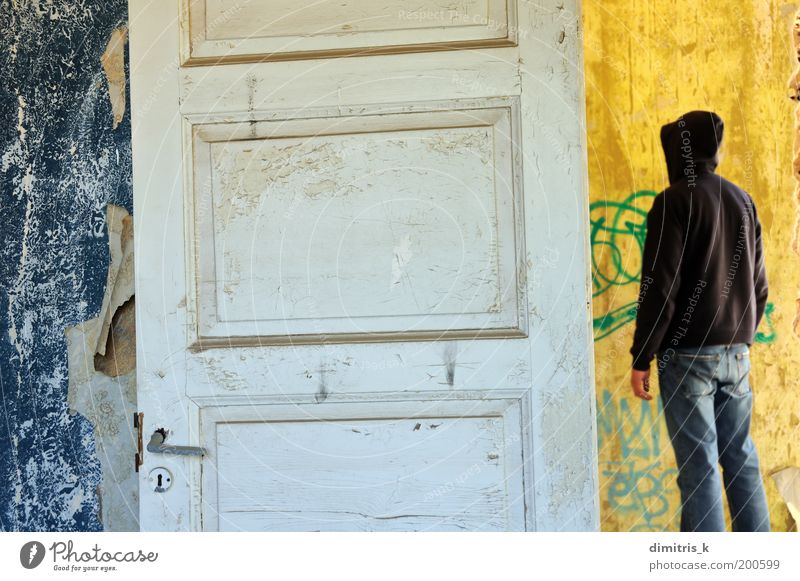 Kapuzenfigur Tapete Raum Mann Erwachsene 1 Mensch Menschenleer Einfamilienhaus Ruine Mauer Wand Tür Graffiti alt dreckig retro trist blau gelb weiß Einsamkeit
