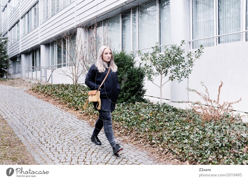 Junge Frau beim Spaziergang in der Stadt Lifestyle elegant Stil Jugendliche 18-30 Jahre Erwachsene Mantel Tasche blond langhaarig gehen Coolness trendy
