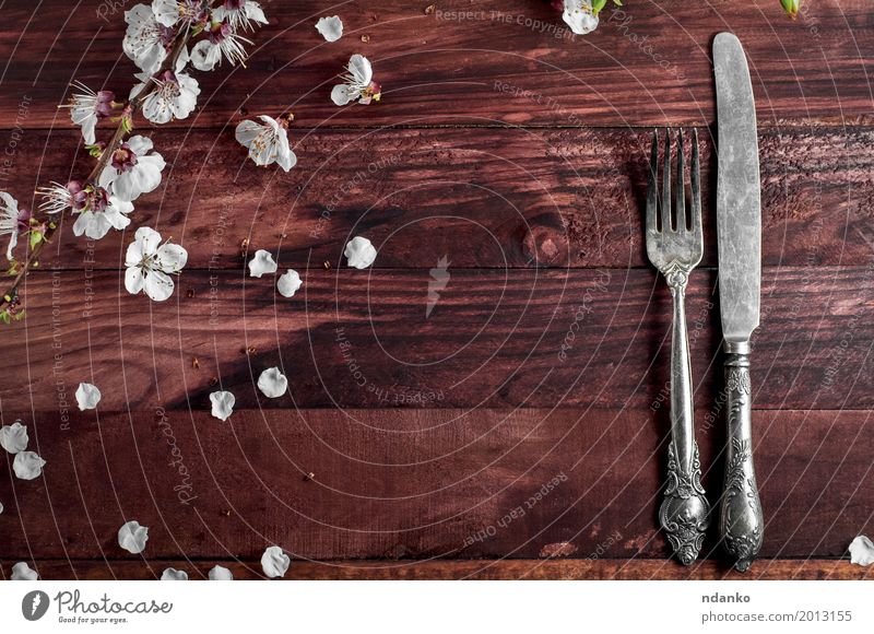 Tischbesteck Messer und Gabel auf einem braunen Tisch Besteck Küche Restaurant Werkzeug Blume Holz Metall alt oben weiß Kulisse Silberwaren speisend