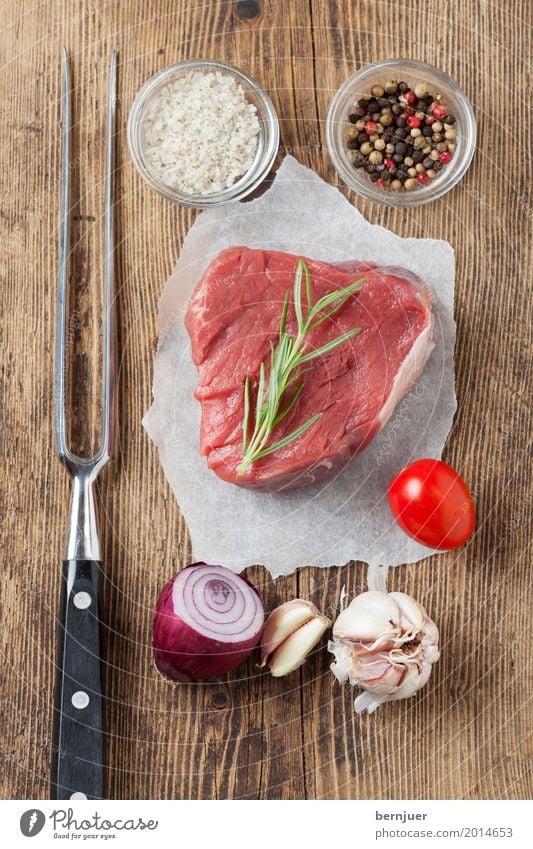 rohes Steak auf Holz Fleisch Kräuter & Gewürze Gabel Papier frisch rot weiß Ausfischt Rindersteak Rindsfleisch Knoblauch Tomate Zwiebel Salz Fleischgabel