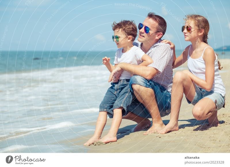 Vater und Kinder sitzen am Strand in der Tageszeit. Konzept der glücklichen freundlichen Familie. Lifestyle Freude Leben Erholung Freizeit & Hobby Spielen