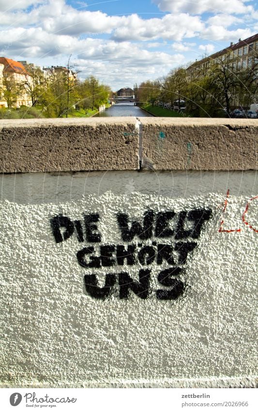 Die Welt gehört uns/Slight return Himmel Stadtzentrum Mauer Wand Putz rau Menschenleer Textfreiraum Stadtleben Wetter Sommer Wolken Schriftzeichen Aufschrift