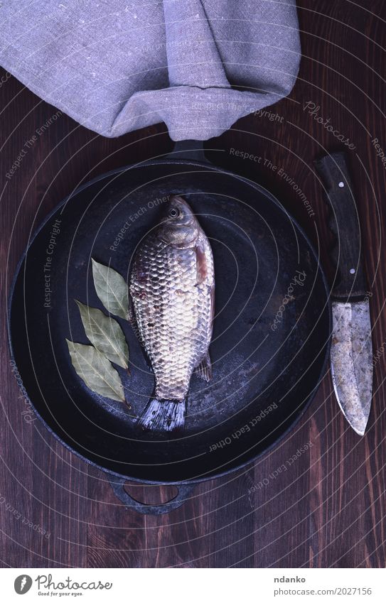 Frischer Flusskarpfen in einer schwarzen Gusseisenbratpfanne Fisch Kräuter & Gewürze Diät Pfanne Messer Holz Essen oben retro braun Kruzianer Lebensmittel Koch
