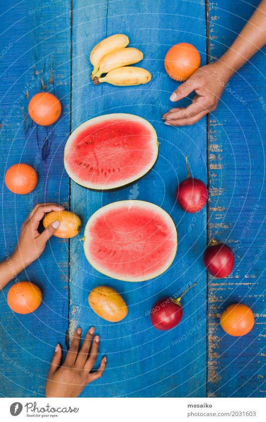 bunte tropische Früchte auf blauem hölzernem Hintergrund Frucht Dessert Vegetarische Ernährung Diät Saft exotisch Freude Sommer Tisch Hand Holz frisch lecker