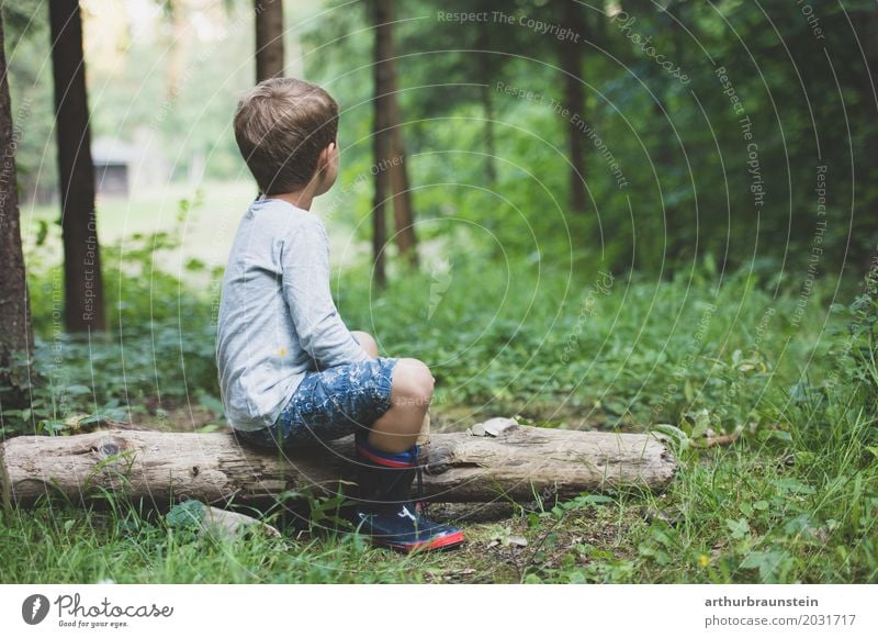 Junge in Gummistiefel sitzt auf Baumstamm in der Natur Freizeit & Hobby Spielen Ferien & Urlaub & Reisen Tourismus Ausflug Abenteuer wandern Kindergarten Schule