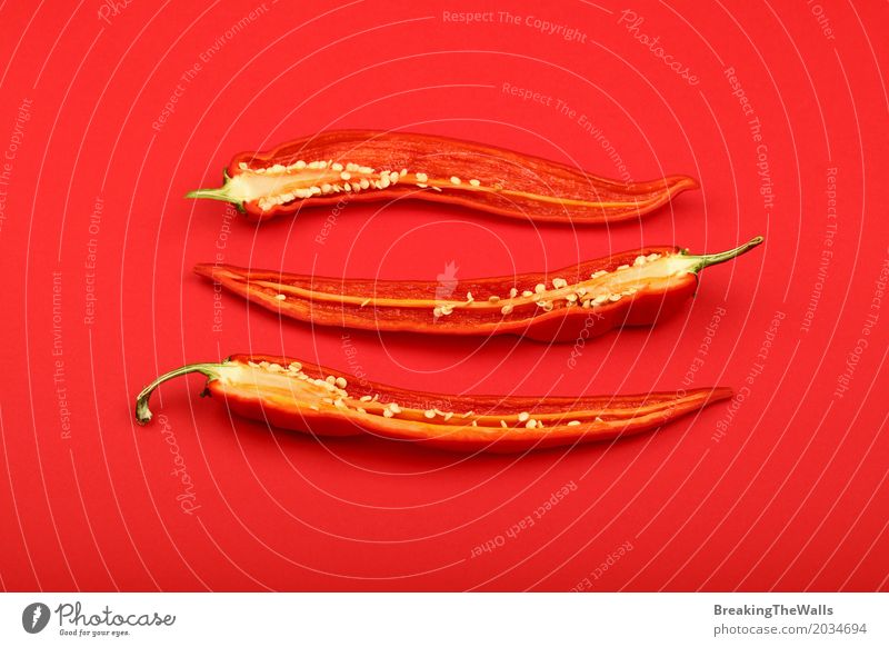 Drei halbierte frische scharfe Paprikapfeffer über Rot Lebensmittel Gemüse Kräuter & Gewürze Ernährung Kunst Papier Aggression heiß rot Farbe Idee Hälfte