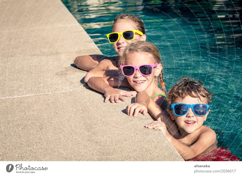 Drei glückliche Kinder, die auf dem Swimmingpool spielen Lifestyle Freude Glück Gesicht Erholung Schwimmbad Freizeit & Hobby Spielen Ferien & Urlaub & Reisen