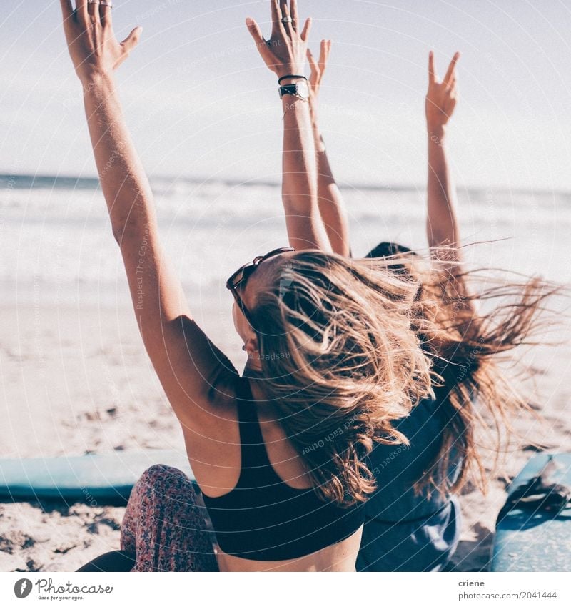 Zwei junge Frau, die mit den Händen oben am Strand zujubelt Lifestyle Freude Freizeit & Hobby Ferien & Urlaub & Reisen Tourismus Abenteuer Freiheit Sommer