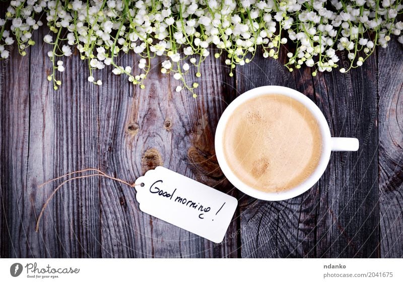 Weiße Tasse mit Kaffee auf einer grauen Holzoberfläche Frühstück Espresso Tisch Restaurant Blume Blumenstrauß frisch gut heiß oben retro braun weiß Café Tag