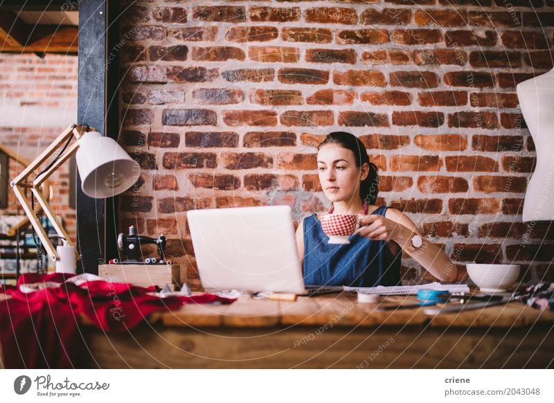 Junge Geschäftsfrau, die an Laptop arbeitet und Kaffee trinkt trinken Lifestyle Freizeit & Hobby Häusliches Leben Schreibtisch Arbeit & Erwerbstätigkeit Büro