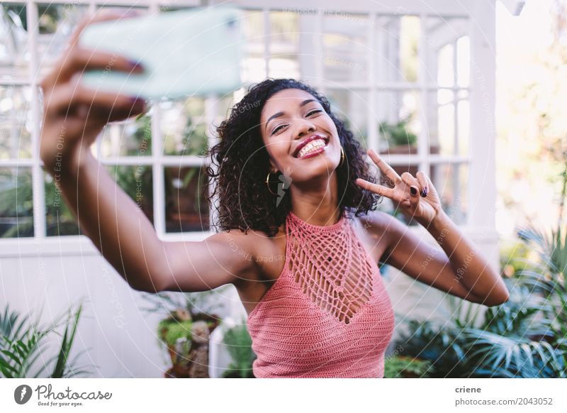 Glückliche afrikanische junge Frau, die selfie mit Telefon nimmt Lifestyle Freude Sommer Garten Handy PDA Fotokamera Technik & Technologie