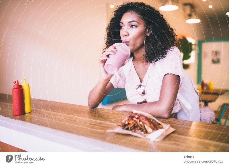 Junge Afroamerikanerin bei Milchshake und Pommes in der Bar Essen Mittagessen Abendessen Fastfood trinken Lifestyle Restaurant feminin Junge Frau Jugendliche
