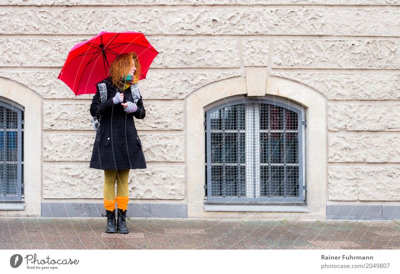 eine Frau steht mit einem Regenschirm und wartet Mensch feminin Erwachsene 1 Stadt Fußgänger Mantel Accessoire langhaarig stehen warten "Wetter Fassade traurig